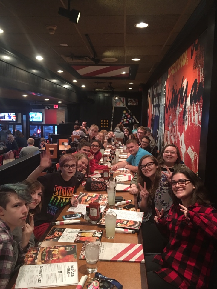 18 students sitting down to dinenr at 1 table.