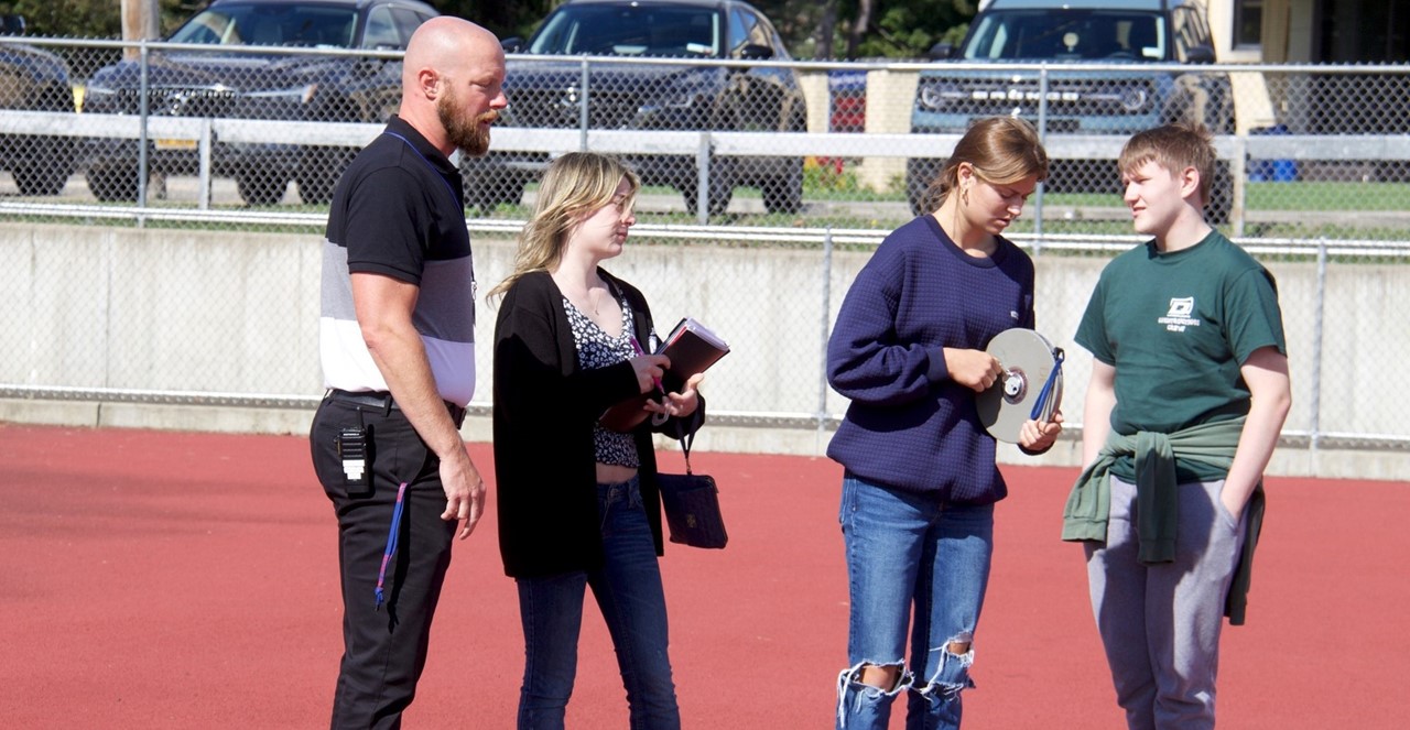 Mr. Diemer and physics student outside experiment
