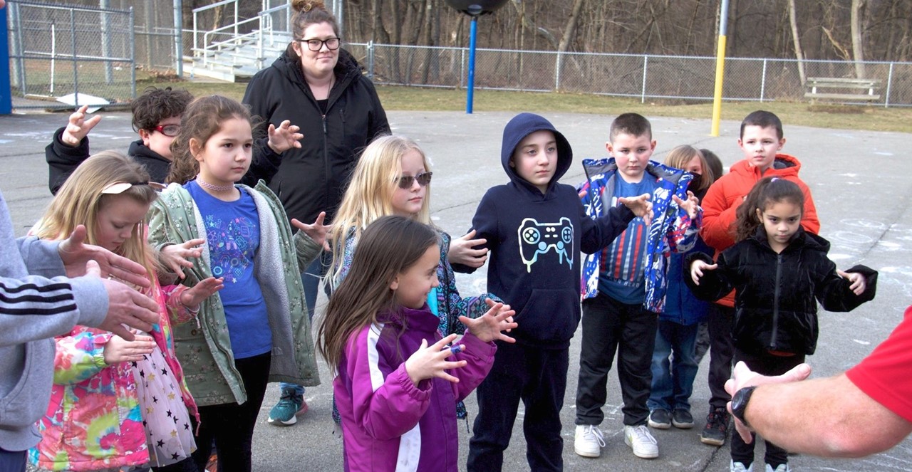 Students during outside activity gesture with hands